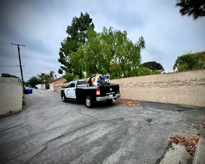 An after pick of a police truck load with with trash and abandoned items. The alley is now clean.